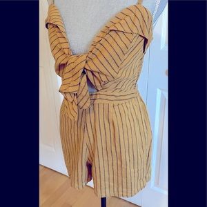 Striped short romper with tie front and peek-a-boo opening.